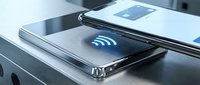 Smartphones displaying wireless connectivity symbols on modern desk surface with notebook and pen for business communication concepts.
