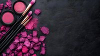 Pink makeup cosmetics with rose petals on dark background. Beauty products including blush, lipstick and brushes for feminine glamour and skincare routine.