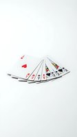 Playing cards spread in fan formation on white background, showing hearts, diamonds, clubs and spades suits for gaming, gambling and entertainment concepts.