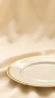 Elegant empty plate with gold rim on soft beige fabric background, suitable for fine dining, luxury tableware, restaurant menus, and upscale event design projects.