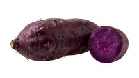 Purple sweet potato whole and sliced in half, isolated on white background for culinary, food styling, recipe development, and ingredient photography use.