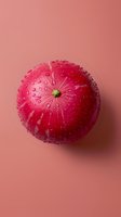 Fresh red apple with water drops on pink background, minimalist food photography composition showing natural texture and freshness of fruit.