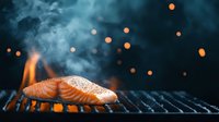 Fresh salmon fillet grilling on barbecue with smoke and orange bokeh lights in dark moody atmosphere, close up view of seafood preparation.