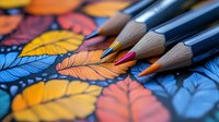 Colorful autumn leaves pattern with sharp wooden pencils in close up macro shot, artistic composition with selective focus on drawing supplies.