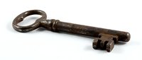 Antique iron key with ornate oval handle and decorative shaft, isolated on white background, suitable for vintage design, historical illustrations, and antique collection displays.