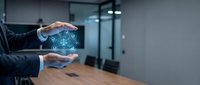 Professional businessman protecting digital healthcare icons with hands in modern office environment for medical technology and insurance concepts.