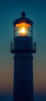 Illuminated lighthouse tower against darkening sky at dusk, with bright beacon light glowing through glass dome structure creating atmospheric maritime scene.