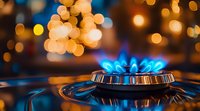 Blue gas stove flame burning with golden bokeh lights in background, close up view of kitchen cooktop burner creating cozy atmospheric mood.