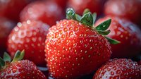 Fresh ripe strawberries with detailed texture and seeds in macro photography, vibrant red color and green leaves against dark background with soft bokeh effect.