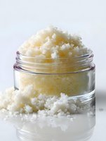 Homemade sugar scrub in glass jar for natural skincare routine, spa treatment and body exfoliation on white background.