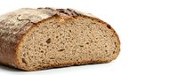 Freshly baked artisan sourdough bread loaf with rustic crust and airy crumb texture, sliced to show interior structure on white background.