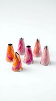 Colorful pastry piping bags with metal tips in pink, magenta, orange and coral watercolor patterns on white background for baking and cake decorating tutorials.