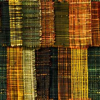 Abstract patchwork pattern in autumn colors featuring distressed woven texture strips in green, orange, and yellow creates rustic geometric design. Seamless repeat.