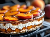 Layered dessert cake with caramelized peach slices, whipped cream filling, and crispy base, perfect for bakery menus, food blogs, and culinary publications.