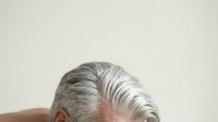 Mature woman with gray and white hair styled back, isolated on white background, suitable for healthcare, beauty, aging, and wellness design projects.