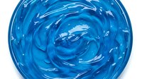 Vibrant blue paint swirl with glossy texture, isolated on white background, suitable for design projects, packaging, and creative compositions.