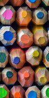 Colorful macro view of wooden colored pencils from their sharpened ends creating an abstract geometric pattern. Perfect for education, creativity, and artistic design backgrounds.