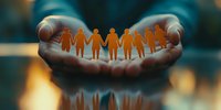 Cupped hands holding paper chain people silhouettes against blurred teal background, symbolizing community support, unity and social care concept.