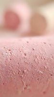 Close-up of finely textured pink powder with soft-focus cosmetic applicators in background, suitable for beauty, makeup, and skincare product marketing.