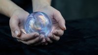Hands holding glowing crystal ball with mystical light effects for fortune telling and spiritual guidance concepts.