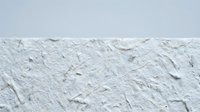 White textured wall surface with rough plaster finish and natural imperfections for interior design and architectural backgrounds.