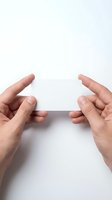 Hands holding blank white card isolated on white background, ready for design mockups, business cards, gift cards, or promotional materials.