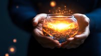 Magical glowing glass jar with golden sparkles and light particles held in hands against dark background, creating mystical atmosphere.