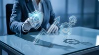Businessman in blue suit holding digital security shield with lock icon and gear symbols on tablet screen, representing cybersecurity protection and data safety.