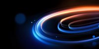 Glowing spiral light trails with blue and orange neon effect against dark background create dynamic motion and energy flow for technology and abstract designs.