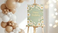 Happy Birthday sign with floral border on easel surrounded by beige and white balloon garland for party celebration and event decoration.