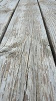 Weathered wooden deck planks with natural grain texture and rustic charm for outdoor construction and renovation projects.