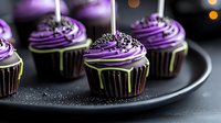 Dark chocolate cupcakes with vibrant purple buttercream frosting and silver sprinkles on black plate. Halloween party dessert with dripping glaze effect.