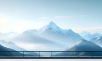 Scenic mountain peak view from observation deck with metal railing, misty morning atmosphere creates layered silhouettes of snow-capped alpine ranges.