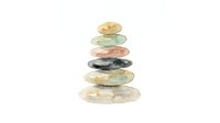Stacked smooth stones in warm and cool tones creating a balanced zen tower on white background, suitable for wellness and meditation design projects.