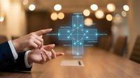 Businessman hands presenting digital healthcare cross with medical technology network connections in modern office environment.