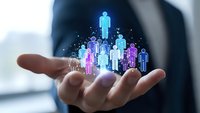 Businessman holding glowing digital human icons representing team management, HR solutions, and workforce analytics in corporate environment.