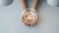 Young adult with light skin tone holding glowing brain hologram, representing artificial intelligence, innovation, and technology concepts for business and education applications.