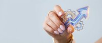 Caucasian woman's hand holding glowing neon arrow and gear icons symbolizing business growth, success strategy, and digital transformation for corporate marketing and technology concepts.