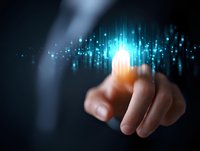Finger touching glowing digital interface with blue light particles and sparkles emerging in dark background, representing future technology and innovation.