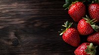 Fresh ripe strawberries scattered on dark rustic wooden background with copy space for text. Natural food photography with dramatic lighting.
