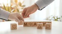 Business professionals collaborating to arrange wooden blocks spelling MAP with icons, symbolizing strategic planning and teamwork in office.