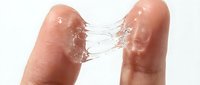Two fingers connected by water droplets and liquid bridges against white background, demonstrating surface tension and fluid dynamics for science and educational content.