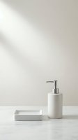 Minimalist bathroom accessories set featuring white ceramic soap dispenser with stainless steel pump and matching soap dish on marble surface with neutral background for home decor styling.