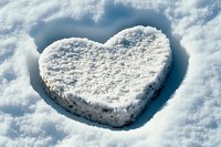 Heart shape formed in fresh white snow with natural sunlight creating soft shadows, romantic winter scene for seasonal greeting cards and valentines designs.
