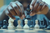 Strategic chess player making decisive move with black king piece during competitive board game match showcasing tactical thinking and mental focus.