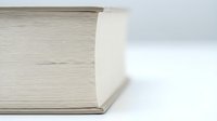 Thick book with yellowed pages lying open on white surface showing aged paper texture and worn binding edge for educational publishing concepts.