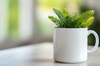 Fresh green fern leaves in white ceramic mug on light surface against blurred background, minimalist home decor and natural interior styling concept.