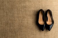 Elegant black leather pointed toe flats on natural burlap background with copy space. Minimalist fashion composition for feminine business style.