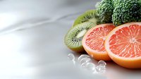 Sliced kiwi and grapefruit with water droplets on white surface, fresh fruit for healthy eating, nutrition, and food styling projects.