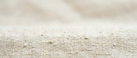 Natural beige linen fabric texture with soft folds and wrinkles, organic cotton material background for textile design and crafting projects.